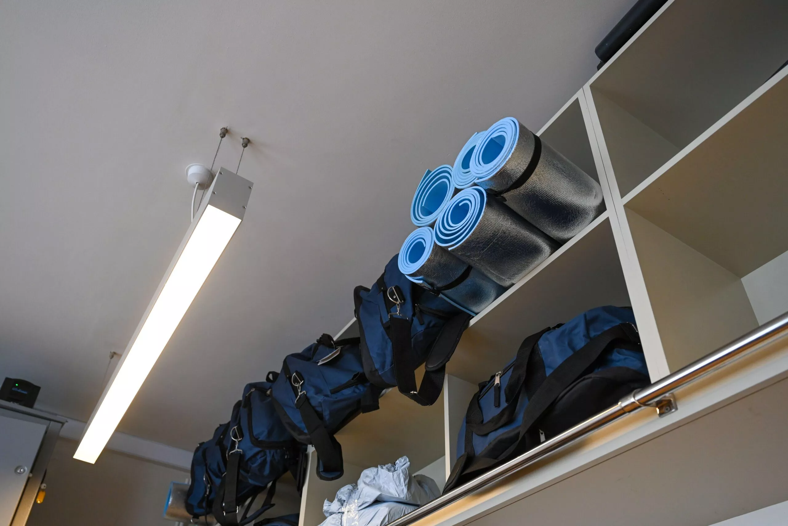 Image of duffle bags and mats on shelves